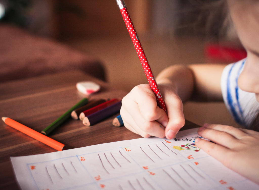 Enfant écrivant au crayon de couleur